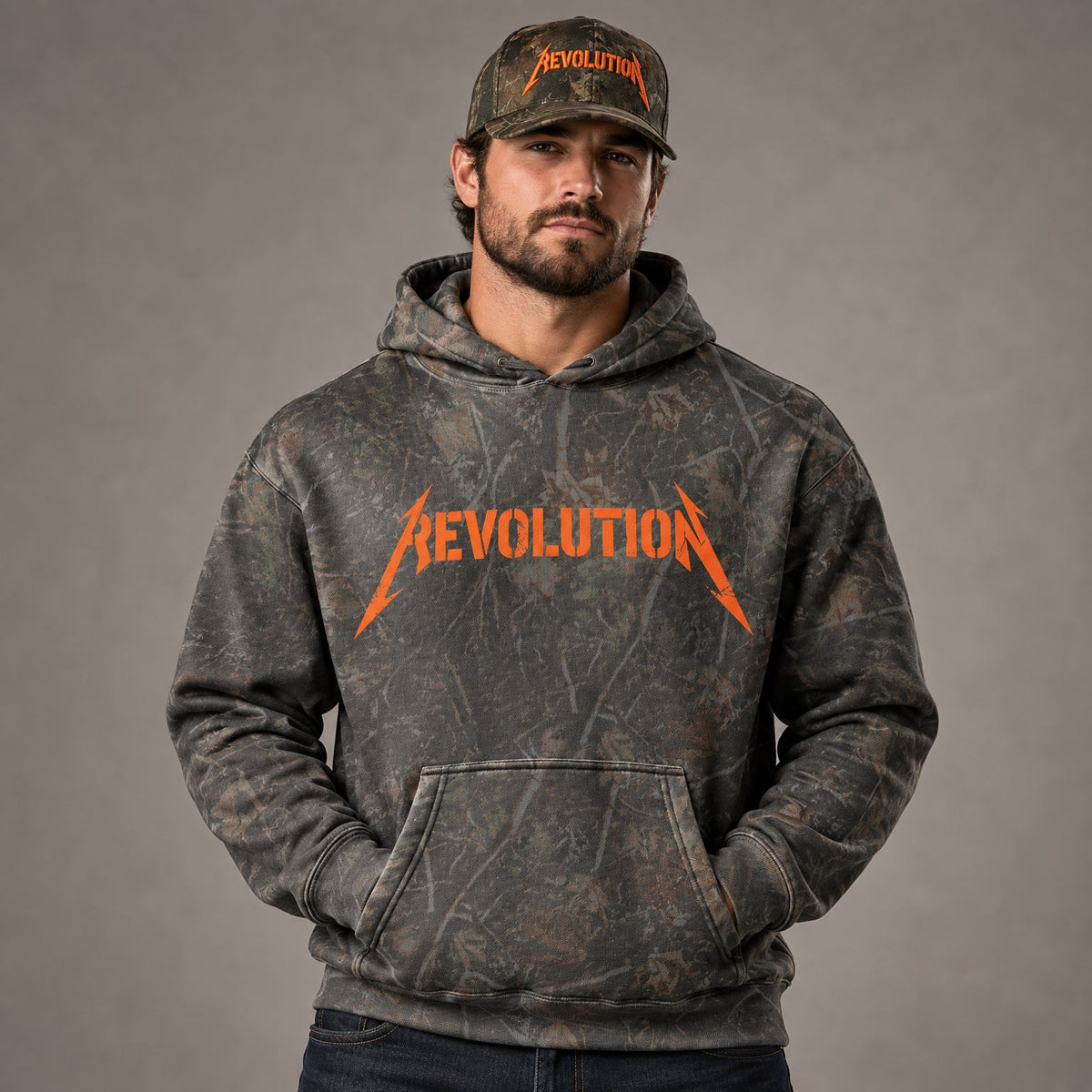 Shocker Logo Camo Heavyweight Hoodie worn by male model in studio, with Cowboy Revolution Backwoods Camo Shocker performance hat