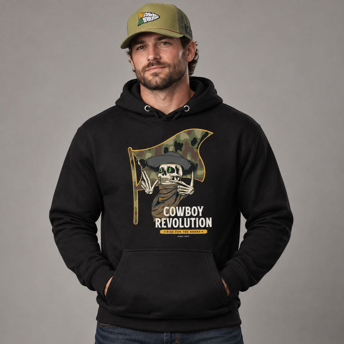 Cowboy Code #7 Ride for the Brand hoodie worn by male model in studio, with Cowboy Revolution Ride For The Brand trucker hat